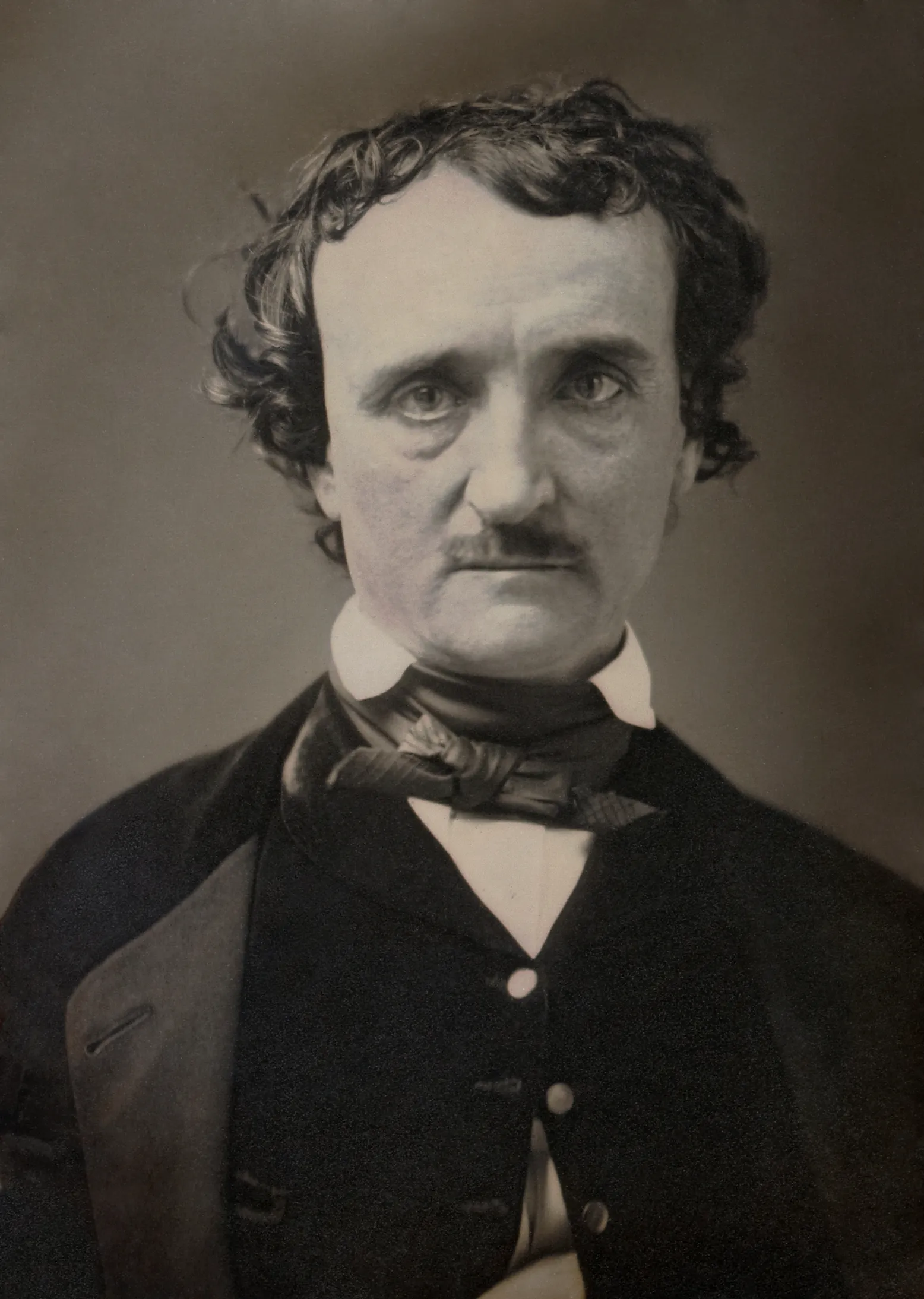 Head and shoulders photographic portrait of Edgar Allan Poe in dark coat and waistcoat, looking towards the camera, daguerreotype, Lowell Massachusetts, June 1849.